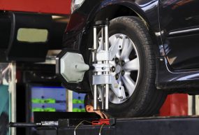 Car wheel fixed with computerized wheel alignment machine clamp.